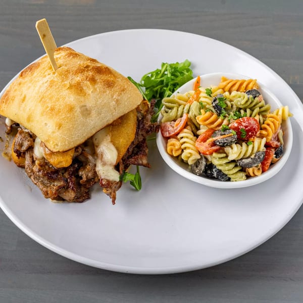 Hutchinson Island Bar and Grille's steak sandwich with melted cheese, served with pasta salad and arugula.